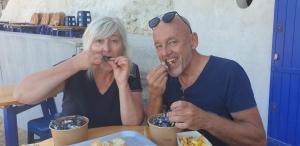 Ein Mann und eine Frau sitzen an einem Tisch und essen in der Unterkunft chambre d'hôte La Paisible in Treize-Vents