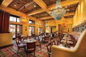 a restaurant with tables and chairs and chandeliers at Gateway Canyons Resort, a Noble House Resort in Gateway