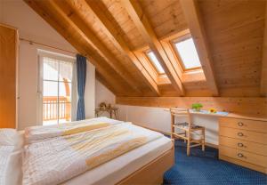 una camera da letto con un letto e una scrivania con una sedia di Dissertorihof ad Andriano