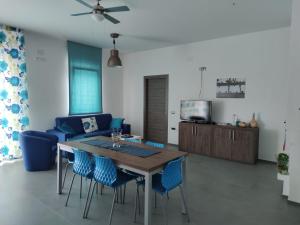 a living room with a wooden table and blue chairs at Tenuta Santa Maria in Mattinata