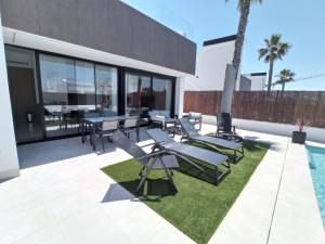 eine Terrasse mit Tischen und Stühlen sowie einem Pool in der Unterkunft Villa Xavi Sucina in Murcia