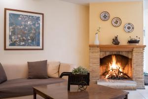 a living room with a couch and a fireplace at Yria Hotel in Zakynthos Town