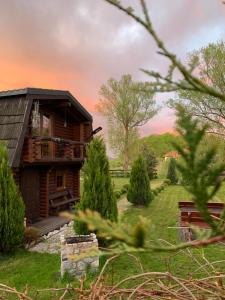 a log cabin in a field with a tree at Domki Florentyna Szklarska Poręba-Wojcieszyce in Wojcieszyce