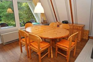 ein Esszimmer mit einem Holztisch und Stühlen in der Unterkunft Zeltdachhaus mit W-LAN - sehr strandnah in Damp
