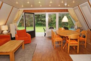 sala de estar con mesa de madera y sillas en Zeltdachhaus mit W LAN sehr strand, en Damp