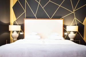 a bedroom with two beds with white sheets and two lamps at Hotel Bamberger Hof Bellevue in Bamberg