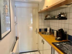 a kitchen with a sink and a white door at Jordan Canal Studio in Amsterdam