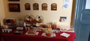 a table with a red table cloth with pastries on it at Hotel Etnea in Catania