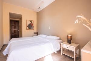 a bedroom with a large white bed and a night stand at Yria Hotel in Zakynthos Town