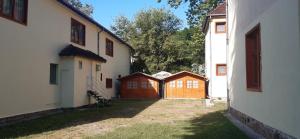 alejka pomiędzy dwoma budynkami z drewnianą bramą w obiekcie Aqua Hostel w Siófoku