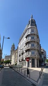 ein großes weißes Gebäude an einer Stadtstraße in der Unterkunft Fabrica Apart in Porto