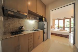una cocina con fregadero y frigorífico en Sayang Sanur Terrace House, en Sanur