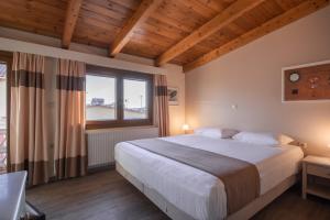 a bedroom with a large bed and a large window at Yria Hotel in Zakynthos Town