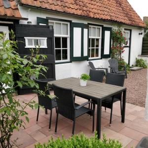Un patio con una mesa y sillas frente a una casa. en Ferienhaus Gapinge Walcheren Zeeland, en Veere 10 fotos más