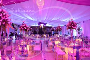 un salón de banquetes con mesas, sillas y flores rosas en Hotel Casablanca Xicotepec, en Xicotepec de Juárez