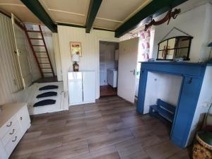 een woonkamer met een blauwe open haard en houten vloeren bij Ferienhaus Gapinge Walcheren Zeeland in Veere