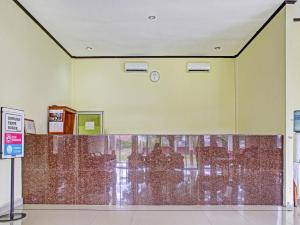 un vestíbulo vacío con una pared de cristal en un edificio en OYO 90423 Hotel Aman en Palangkaraya