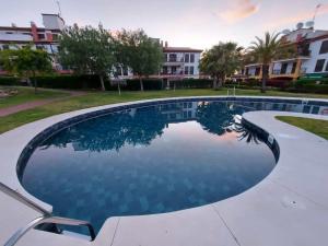 a large swimming pool in a yard with buildings at Apartamento Canela in Ayamonte