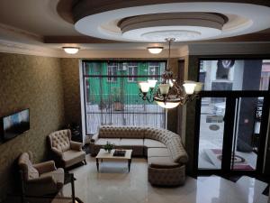a living room with a couch and chairs and a window at Batumi Home in Batumi