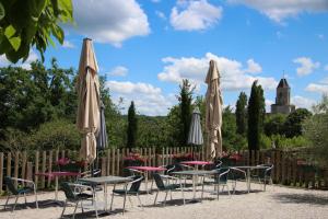 a group of tables and chairs with umbrellas at Auberge des 7 Tours in Martel