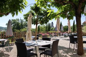 Auberge des 7 Tours في مارتيل: مطعم بطاولات وكراسي مع مظلات