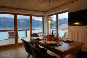 a dining room table with a view of the water at Pension Christina in Unterach am Attersee