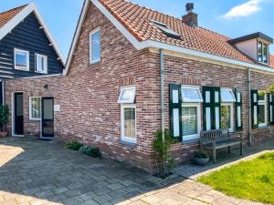 a brick house with a bench in front of it at Het Korenhuus in Lewedorp