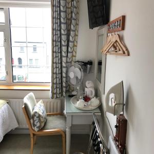 Zimmer mit einem Tisch, einem Spiegel und einem Stuhl in der Unterkunft Petra House B&B in Galway