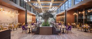 Un comedor con mesas y sillas moradas. en Nirvana Cosmopolitan Hotel - Convention & Sports Center, en Lara