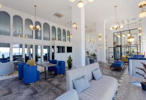 a lobby with a couch and tables and chairs at Panorama Kvariati in Kvariati