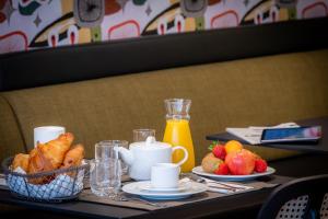 a table with a tray of food and a basket of fruit at Ferdinand Hotel Tours in Tours