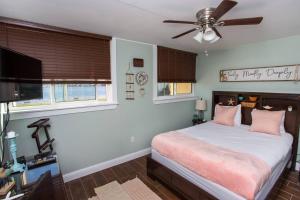1 dormitorio con 1 cama con almohadas rosas y ventilador de techo en Sea Palm Condos 5E, en Fort Walton Beach 22 fotos más