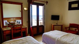 a bedroom with a bed and a desk and a window at Dyarna Dahab Hotel in Dahab