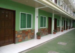 um edifício com paredes verdes e vasos de plantas sobre ele em Reddoorz @ Sta Cruz Naga City em Naga