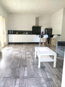 a living room with a white table and a kitchen at Maison d'une chambre avec jardin clos et wifi a Audenge a 3 km de la plage in Audenge