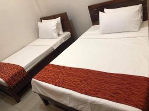 two beds in a hotel room withacers at Reddoorz @ Sta Cruz Naga City in Naga