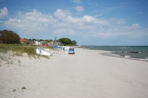 a sandy beach with boats in the water at Schlafstrandkorb Nr. 3 in Sierksdorf