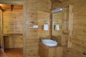 a bathroom with a white sink and wooden walls at WelcomHeritage Lha-ri-sa Resort in Leh