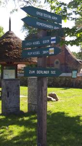 ein Straßenschild mit vielen Schildern auf einem Feld in der Unterkunft Zimmer und Apartment Rosi in Krakow am See