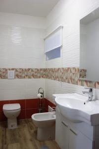 ein Badezimmer mit einem weißen Waschbecken und einem WC in der Unterkunft Terra e Cielo in Pagani