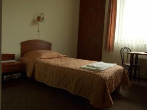 a bedroom with a bed and a table and a window at Pastoral Lodge at the Sanctuary of the Divine Mercy in Kraków