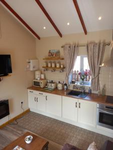a kitchen with white cabinets and a sink at Country Cottage Apartment Valentia Island Kerry in Valentia Island