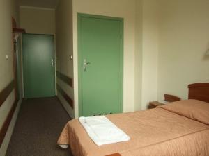 een kamer met een bed en een groene deur bij Pastoral Lodge at the Sanctuary of the Divine Mercy in Krakau