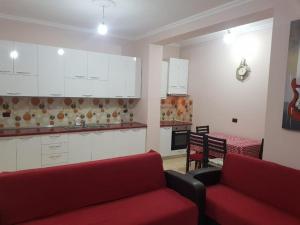 ein Wohnzimmer mit zwei roten Sofas und einer Küche in der Unterkunft LUXURY SEASIDE APARTMENT WITH TWO BEDROOMS 130 meter in Vlorë