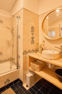 un bagno con un lavandino, una vasca e uno specchio di Perfect for quiet vacation with family and friends a Setúbal Altre 17 foto