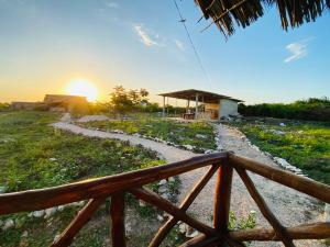 a path leading to a house with the sunset in the background at Habibis Bottle House in Nungwi