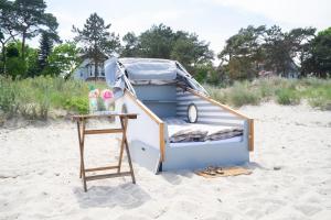 una casetta sulla spiaggia con un tavolo di Schlafstrandkorb Nr. 4 a Timmendorfer Strand