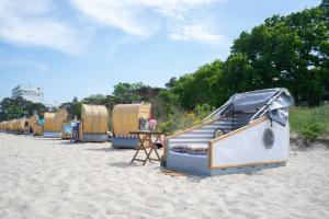 a row of beach huts on a sandy beach at Schlafstrandkorb Nr. 4 in Timmendorfer Strand