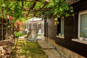 een achtertuin met een schommel onder een pergola bij Villa Beni ~ 4-Bedroom Private House in Lozenets