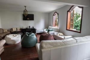 een woonkamer met een witte bank en stoelen bij Pousada 45 Hostel in Belo Horizonte